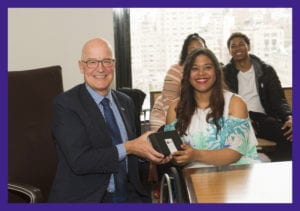 NYU President Andrew D. Hamilton bestows honors to distinguished undergraduate student Johileny Meran, May 2019. For more information, review Image Description below.