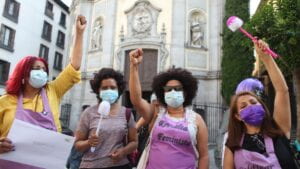 Four female activists with fists in the air outside Spanish legislative hall on the day of C189 ratification