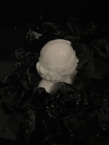 resin mold of a woman's head surrounded by black crystal rocks