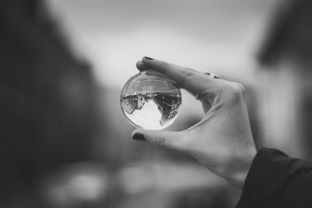 A hand holding a small crystal ball.