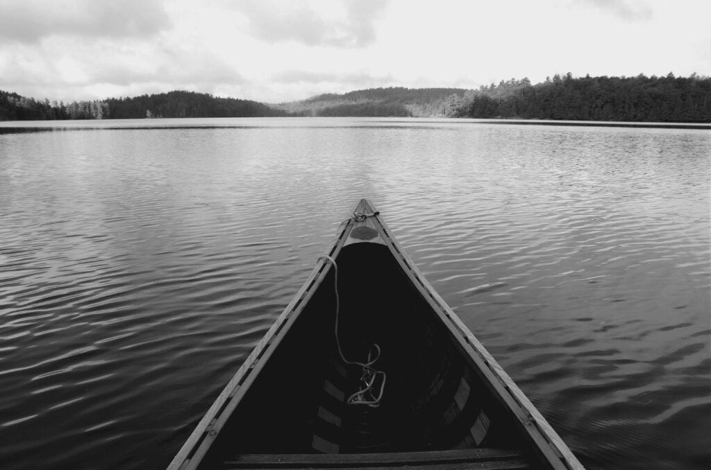 A canoe on a lake in the woods.