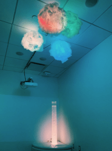 Bright vertical tube with bubbles inside and colorful lights shining out of it