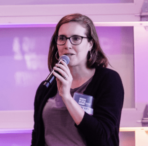 Headshot of Amy Hurst speaking into a microphone. 