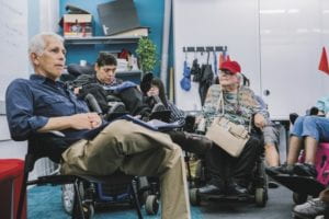  Allan Goldstein sitting with people with disabilities in classroom.