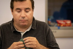 A torso shot of an attendee against handling a circuit board.