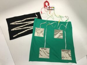 A large green mat and smaller black mat embellished with silver conductive material, wired to a Makey Makey. 