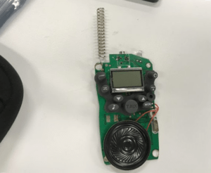 A walkie-talkie with exposed circuit board and wiring. 