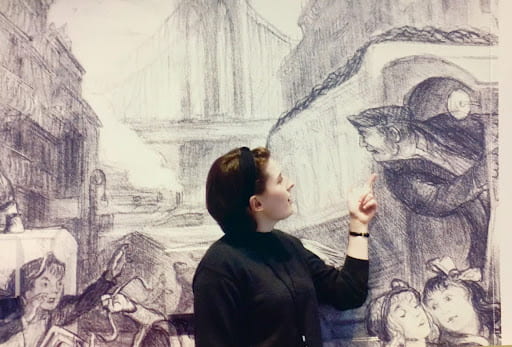 Emma Gyorgy in front of an image from the exhibit.