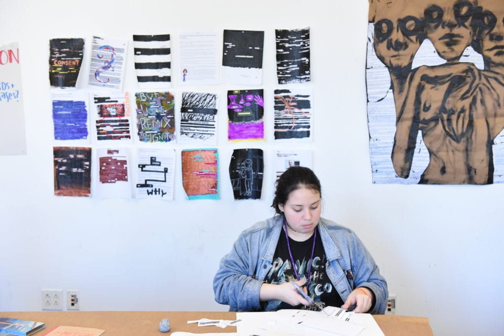 Student sitting at a table and working on her project.