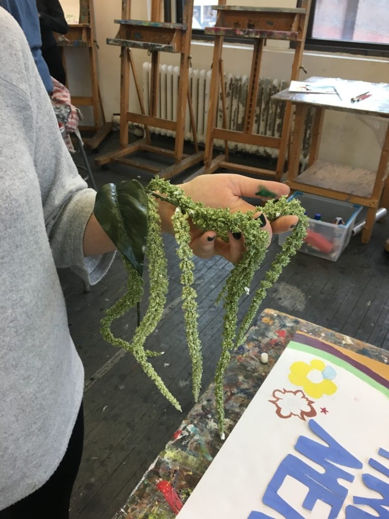 Student holding green vine