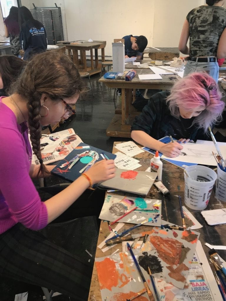 Two students working on collages. 