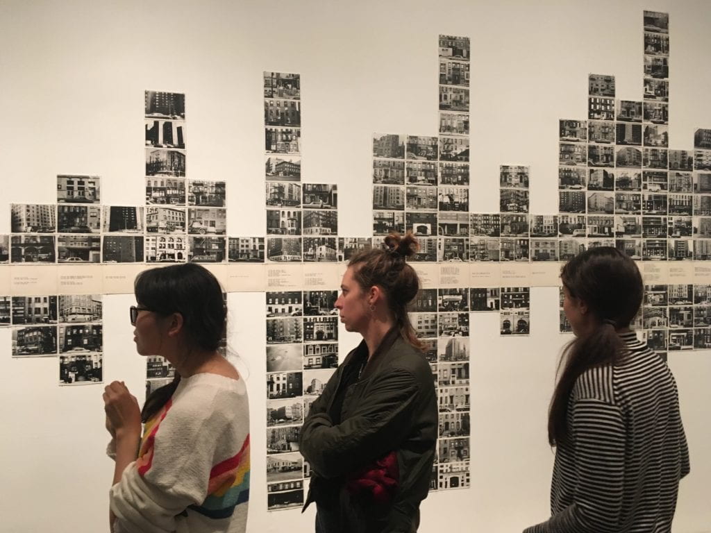 Three alumni looking at a Hans Haacke installation at the New Museum.