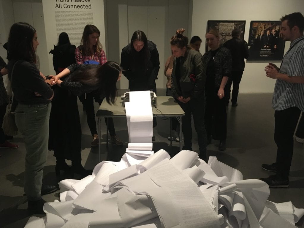 Tour group looking at a Hans Haacke installation at the New Museum.