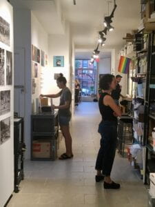 Image of two people looking at book shelves and documents in a hallway space