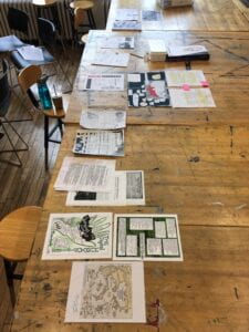 Image of a table with many different drawings and documents organized in a row