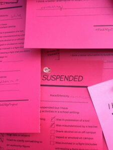 A detail of a 'pink slip' suspension card from the bulletin board