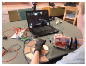 A person playing a computer game with adaptive controller and mouse platform.