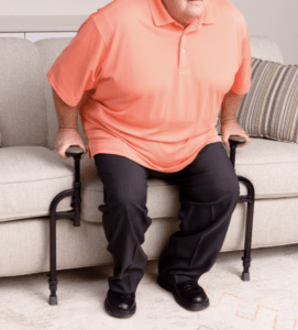 A person is using the handles to push-off to stand up from the couch