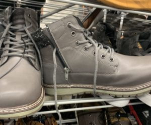 Grey leather boots with the right boot facing forwards and the left boot showing a zipper along the inner lining.