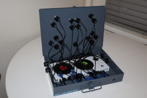 Open metal box with Xbox Adaptive Controller, wires, and buttons inside