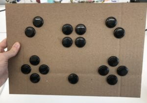 A picture of our cardboard prototype including 17 black buttons.