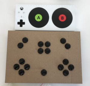 A picture of Xbox Adaptive Controller and our cardboard prototype. Our prototype is slightly bigger than XBox controller so that it can be included in the box.