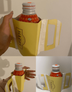 Bottle in a paper holder with handles on the left and right size. 