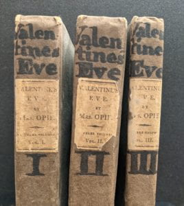 Book spines with handwritten text at top.