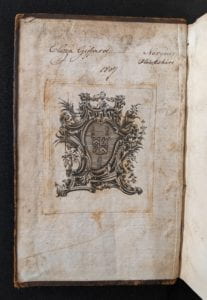 Inside cover of book showing ownership inscription and armorial bookplate.