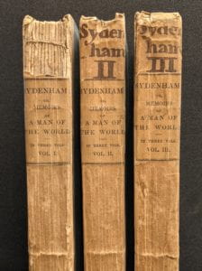 Book spines with handwritten text at top.