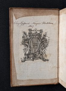 Inside cover of book showing ownership inscription and armorial bookplate.