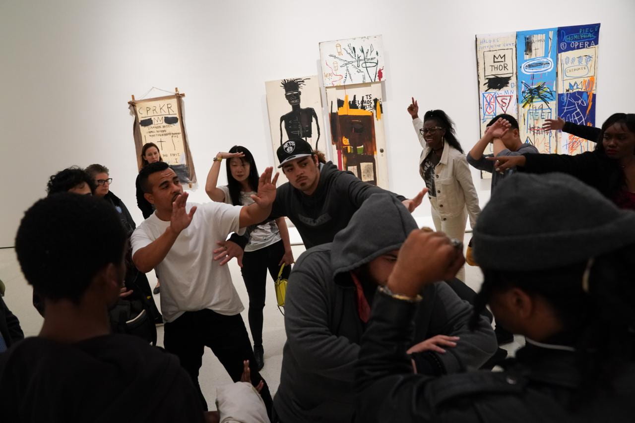 Multiple people in an art gallery interacting through dance movies and gestures.