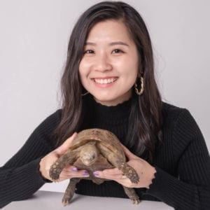 Headshot of the artist holding a turtle