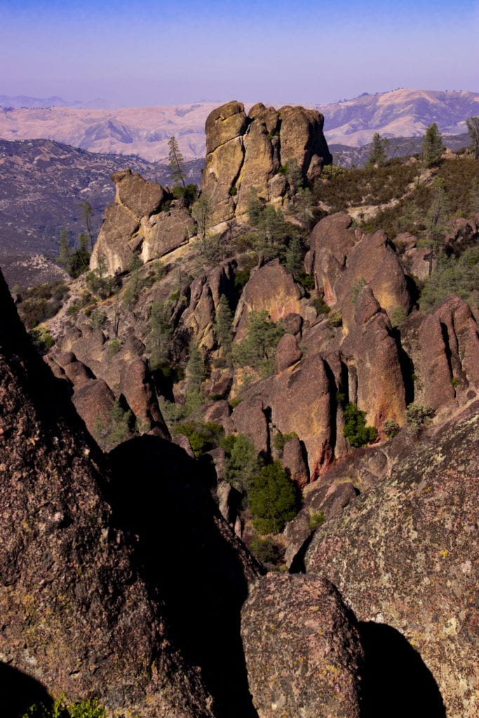Photograph of rock pinnacles with snowy mountains in the background