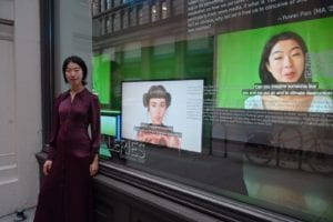 Yuwei Pan in front on the gallery windows with exhibition in the background