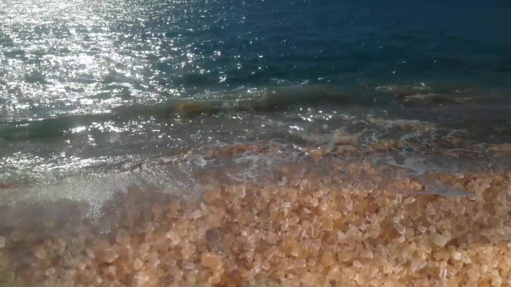 Image of clear ocean water shining with stones beneath the surface.