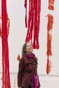 woman standing under strings of red cords