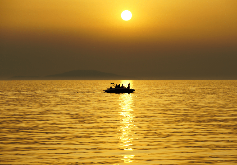 Boat sailing in the distance in sunset.