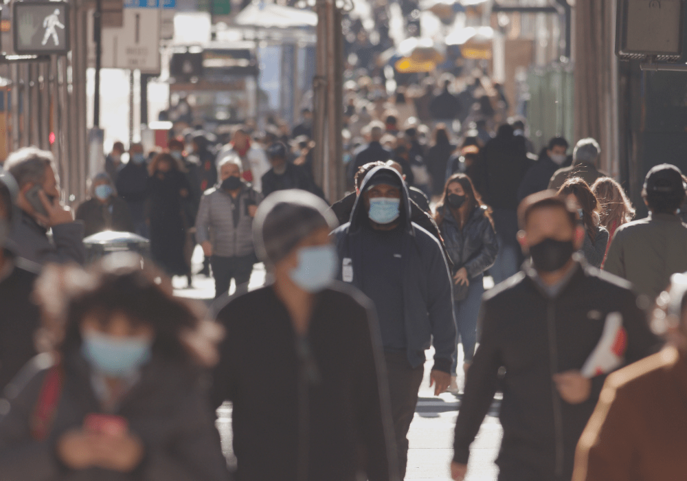 Busy street with people wearing masks