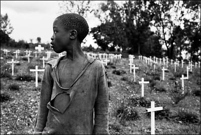 Young boy looking over his shoulder to a graveyard