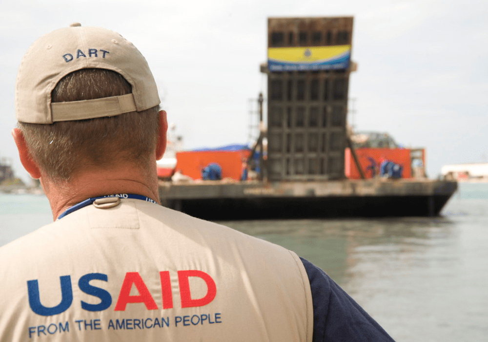 A man working with USAID helps with a shipment of relief supplies.