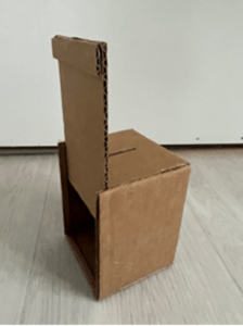 cardboard box with small slit in top to place money. One side wall lifts to access money in the bank.