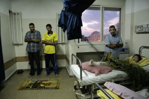 Hospital room with view of landscape from window and pray mat on floor