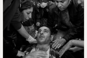 crowd surrounding man laying on ground