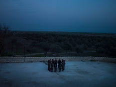 Group of people from a distance standing in a circle