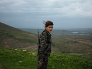 Woman in army gear in front of mountain overlook