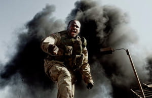 soldier in gear with cloud of black smoke behind him