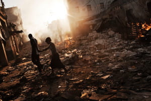 Man and woman walking through rubble lined street. 