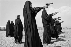 Women in veils pointing guns to the right