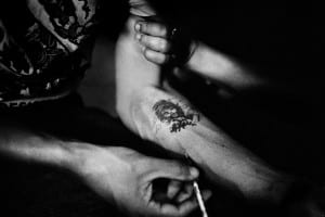 Arm with tattoo receiving a needle